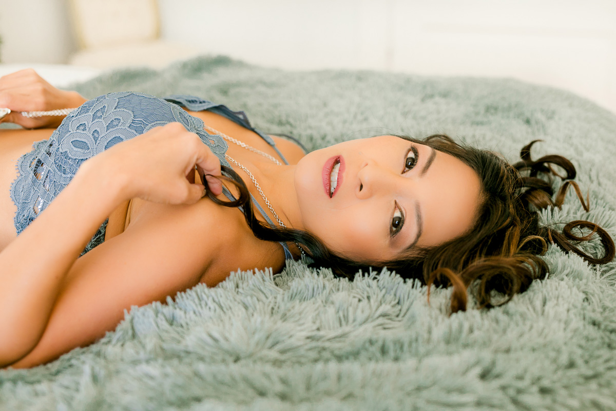 Model mom laying on shag rug in blue lingerie