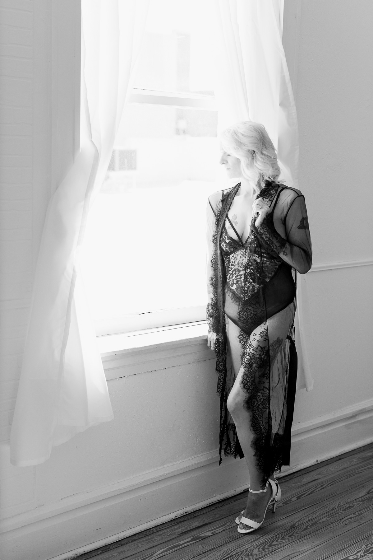 Woman at window in black lace outfit. 