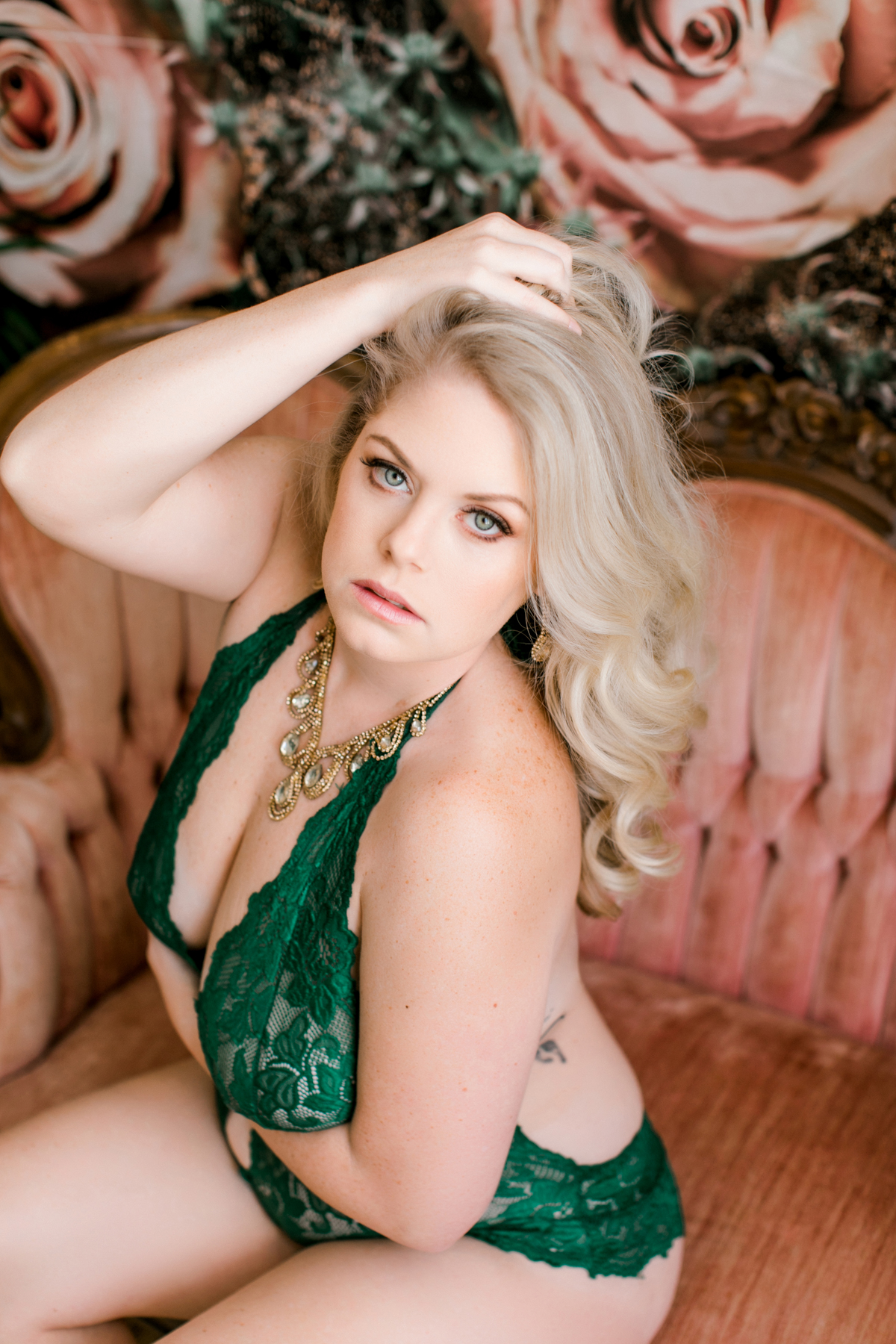 woman with green eyes and green lace bodysuit on vintage sofa