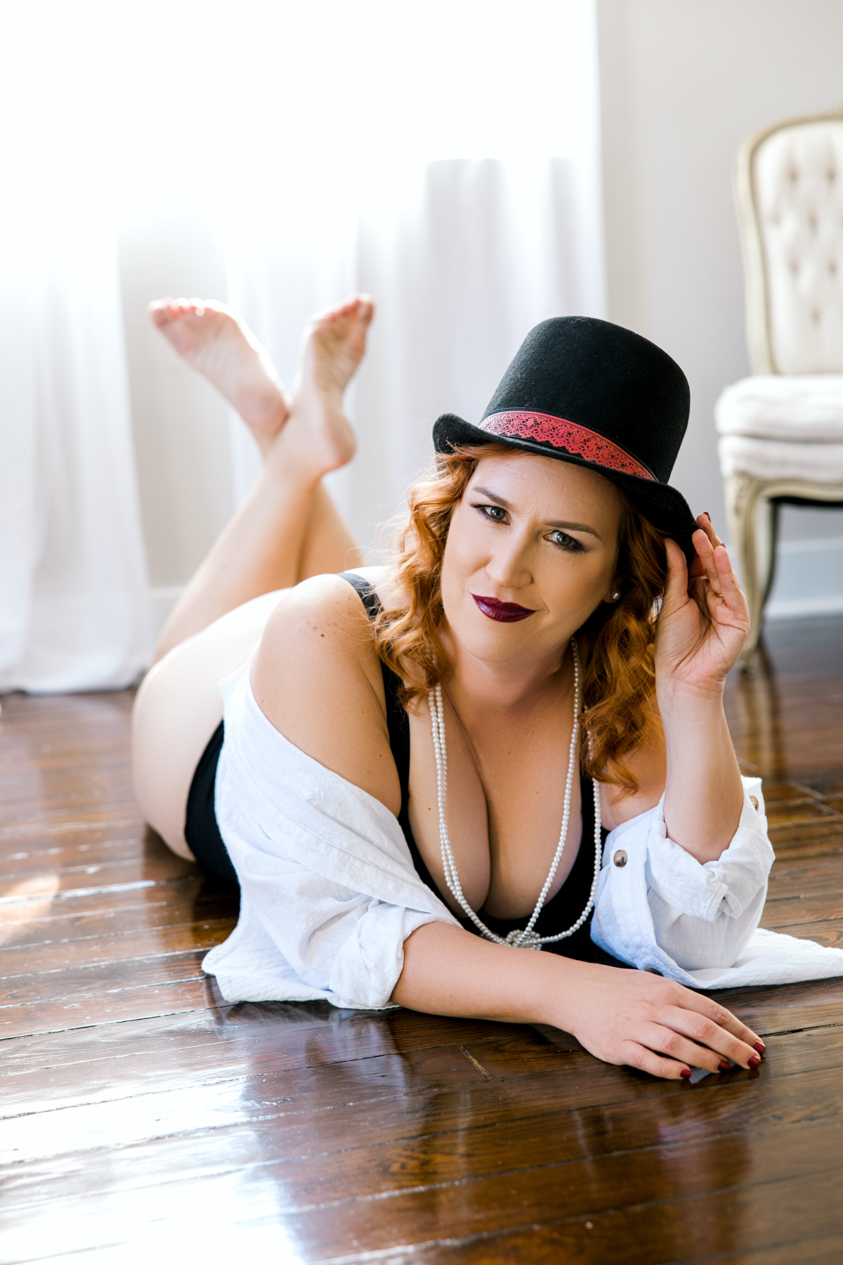 woman laying on floor wearing 80's top hat