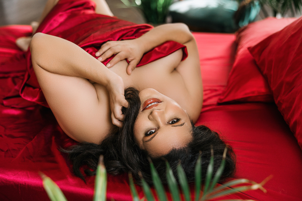 sexy brunette wrapped in red satin sheets